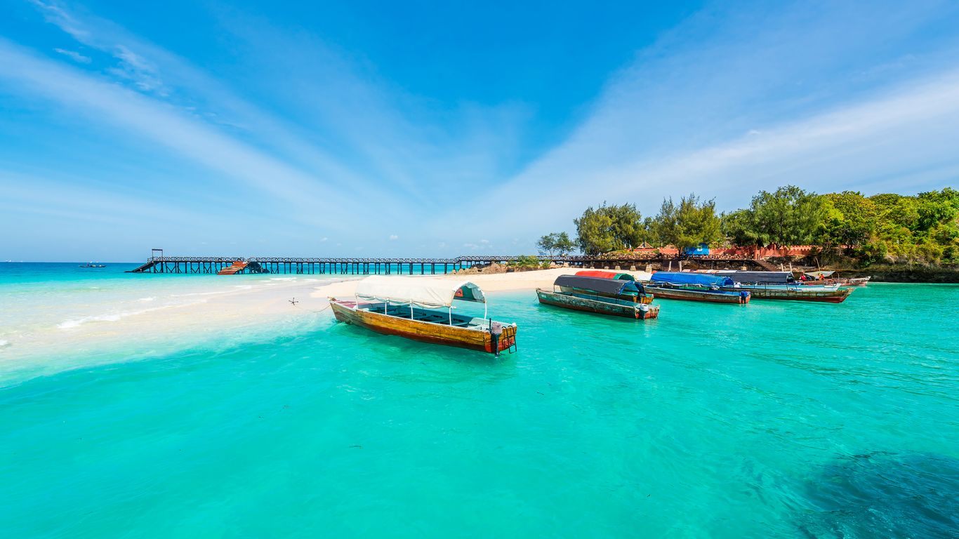 Boats moored in the turquoise water off a Zanzibar beach